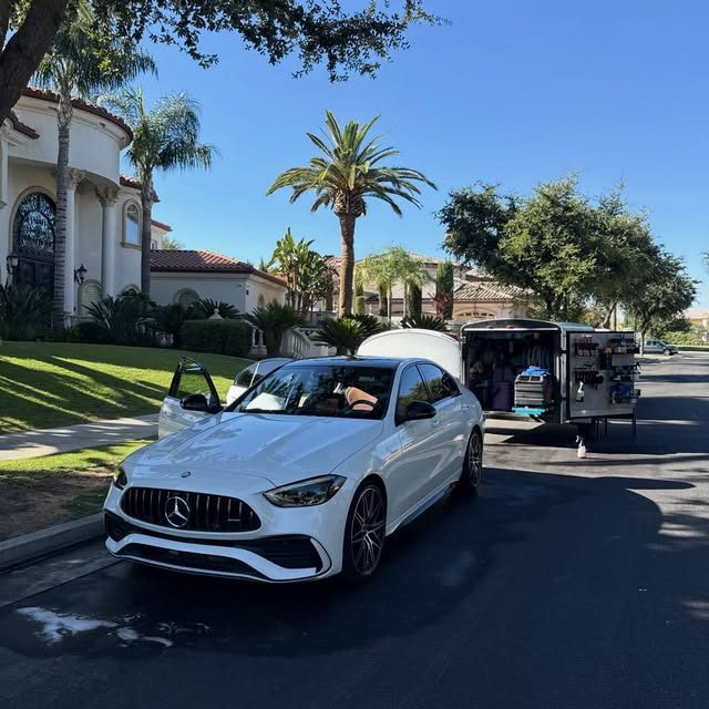 TLC's mobile setup parked at a customer's curb next to a white Mercedes-AMG