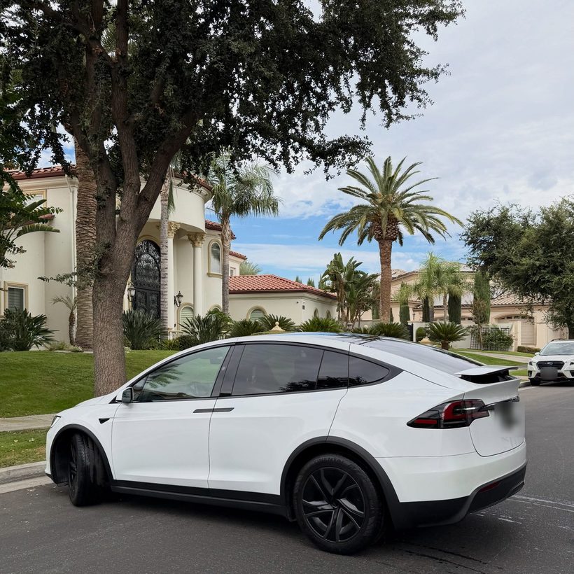 White Tesla Model X in front of a home